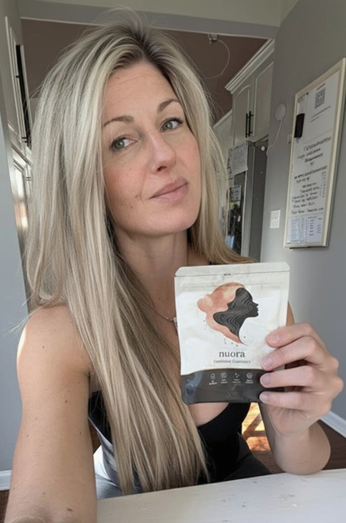 Nuora customer in her kitchen holding a pouch of Feminine Balance Gummies