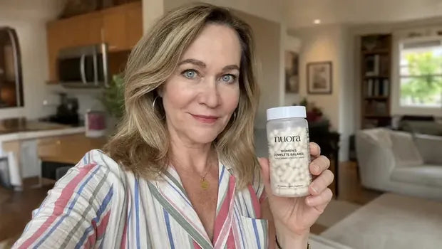 Vanessa holding a Nuora supplement bottle